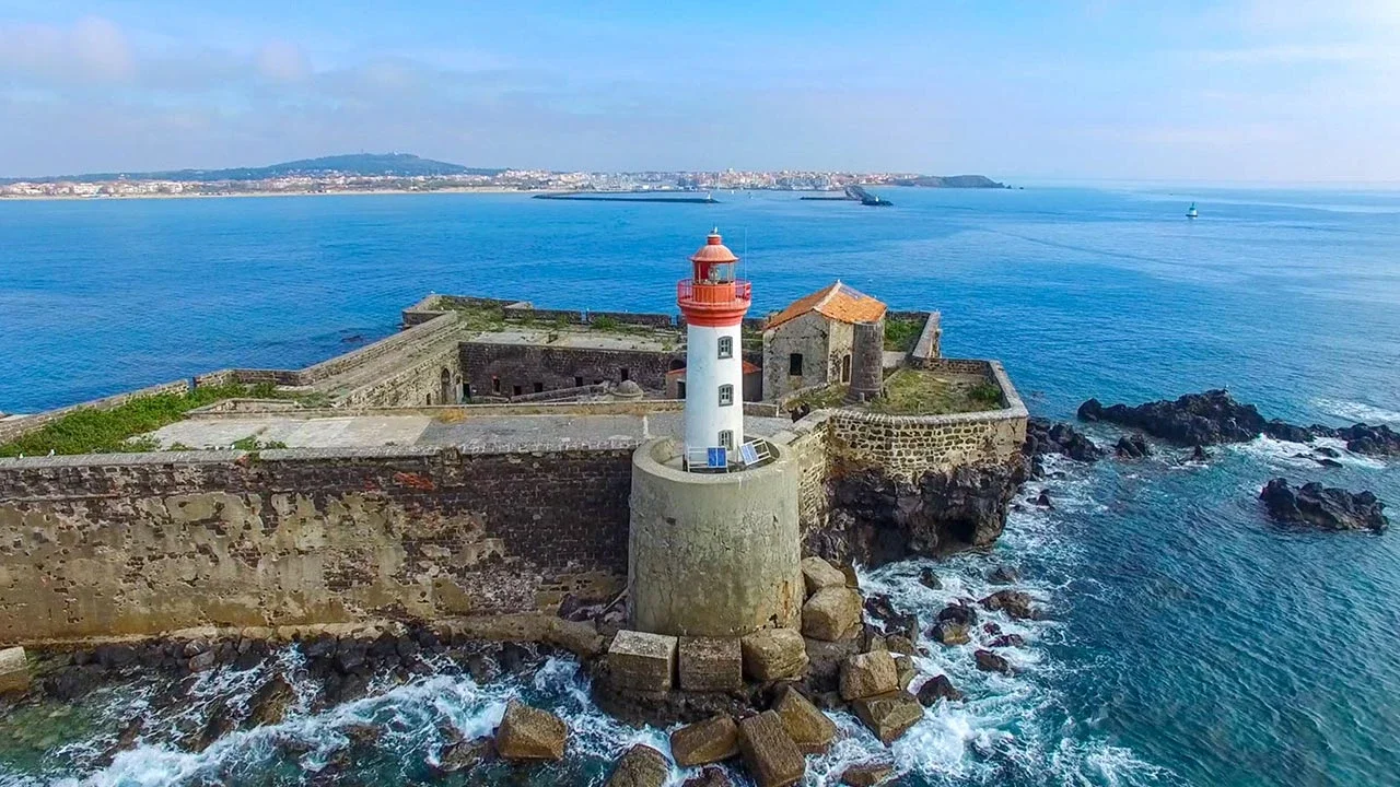 Le Fort Brescou et son phare rouge et blanc sur l'îlot rocheux au large du Cap d'Agde